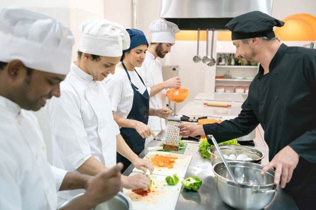 Chef teaching students in kitchen