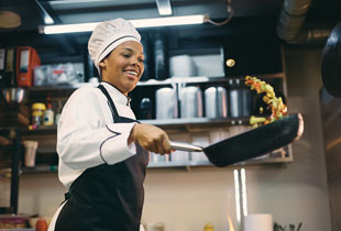 Woman in restaurant kitchen preparing food